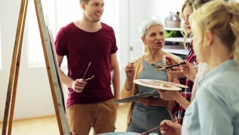 group-of-artists-discussing-painting-at-art-school