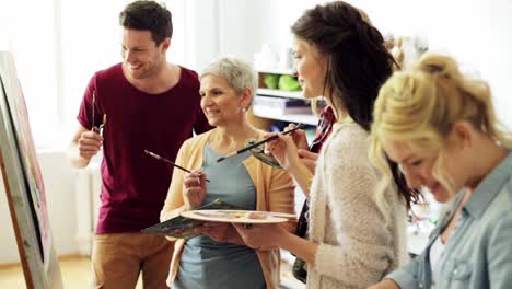 group-of-artists-discussing-painting-at-art-school