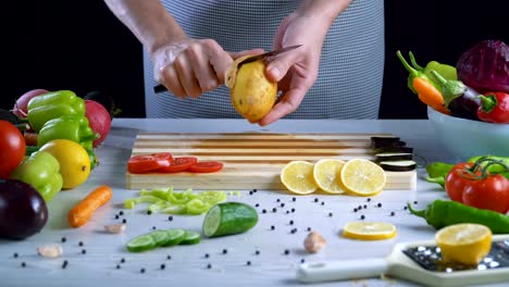 Man-is-peeling-potato-in-the-kitchen