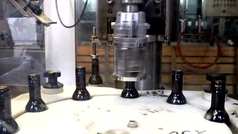 Spinning-caps-on-bottles-of-red-wine-using-professional-modern-equipment