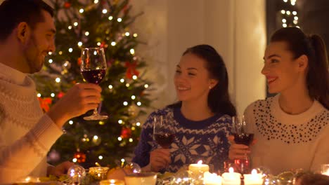 Glückliche-Freunde-trinken-Rotwein-zu-Weihnachten