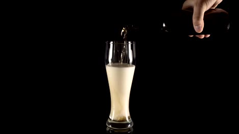 pouring-beer-in-a-beer-glass-on-a-black-background