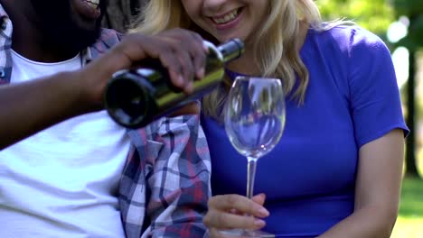 Afro-american-male-pouring-wine-to-girlfriends-glass,-romantic-outdoor-date