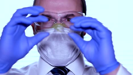 Biologist-examines-sample.-Science,-biology,-ecology.-Professional-scientist-wearing-protective-mask-working-with-herb-samples-in-his-laboratory.-Male-scientist-looking-at-plant-leaf-in-glass-slide.