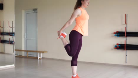 Young-woman-stretching-herself-and-preparing-to-workout