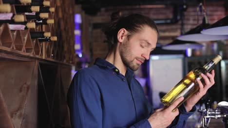 Handsome-Man-Holding-Bottle-Of-Wine-At-Wine-Cellar