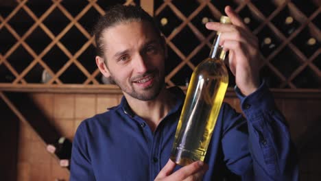 Smiling-Man-With-Bottle-Of-Wine-In-Cellar-At-Winery-Restaurant