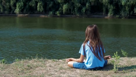 Das-Mädchen-ist-am-Ufer-Flusses-meditieren.