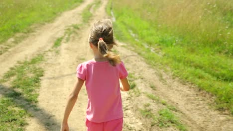 Little-girl-walking-along-a-rural-road