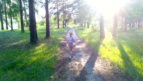 Young-blonde-girl-jogging-on-country-road.-Aerial,-top-view.