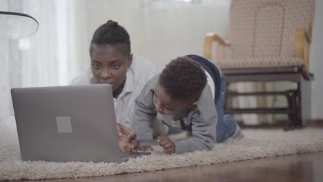 African-american-woman-with-her-cute-son-looking-on-the-laptop.