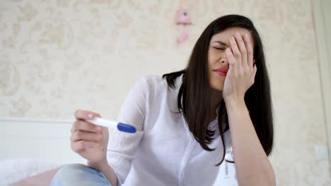 Sad-woman-with-pregnancy-test-at-home