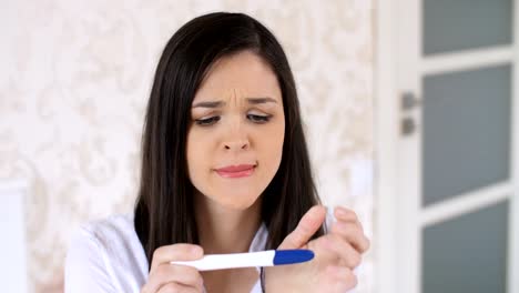 Sad-woman-with-pregnancy-test-at-home