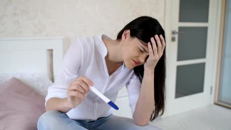 Sad-woman-with-pregnancy-test-at-home