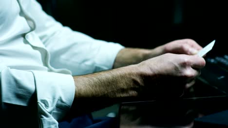 Male-hands-holding-a-business-card--in-the-office-(Macro-Close-up).