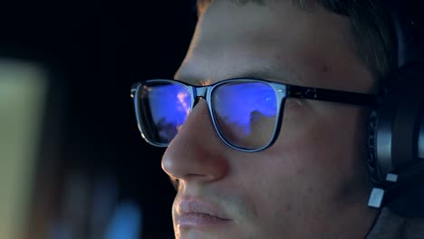 Close-up-of-a-computer-game-reflecting-in-gamer's-glasses