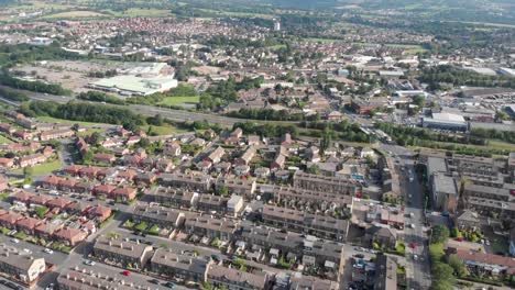 Aerial-footage-of-the-Leeds-town-of-Pudsey-in-West-Yorkshire,-England-showing-typical-British-streets-and-business-taken-on-a-sunny-bright-summers-day.