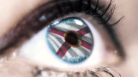 Mujer-ojo-azul-en-primer-plano-con-la-bandera-del-estado-de-Florida-en-iris,-estados-unidos-de-América-con-movimiento-de-viento.-concepto-de-vídeo