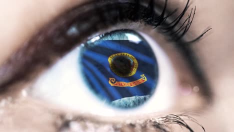 Woman-blue-eye-in-close-up-with-the-flag-of-Idaho-state-in-iris,-united-states-of-america-with-wind-motion.-video-concept