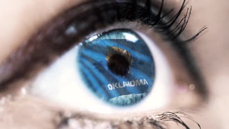 Woman-blue-eye-in-close-up-with-the-flag-of-Oklahoma-state-in-iris,-united-states-of-america-with-wind-motion.-video-concept