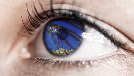 Woman-green-eye-in-close-up-with-the-flag-of-Nevada-state-in-iris,-united-states-of-america-with-wind-motion.-video-concept