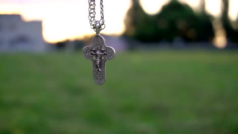 Christian-cross-on-a-chain-on-the-background-of-sunrise