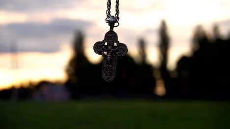 Christian-cross-on-a-chain-on-the-background-of-sunrise