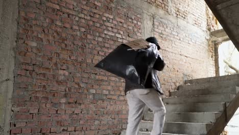 Homeless-up-stairs-with-garbage-bag-behind-his-back