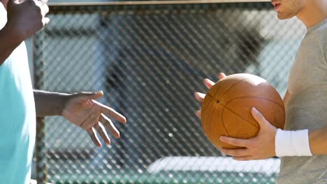 Two-energetic-men-discussing-basketball-game-strategy-and-rules-at-training