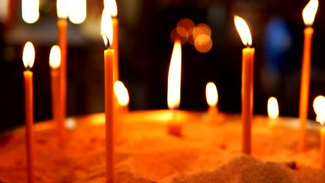 Burning-candles-in-the-sand-in-the-Christian-Orthodox-Church