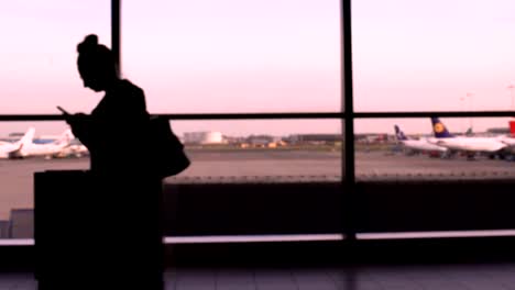 People-with-backpacks-walking-in-airport,-airplanes-on-background,-holiday-trip