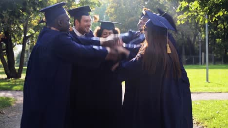 happy-students-in-mortar-boards-with-hands-on-top