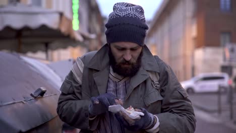 hambre,-pobreza,-desesperación-mendigo-encuentra-un-sandwich-en-el-cubo-de-la-basura