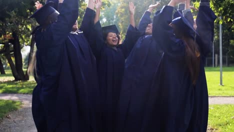 glückliche-Schüler-in-Mörtel-Boards-mit-Händen-an-der-Spitze