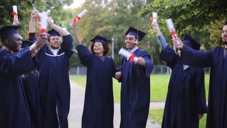 glückliche-Schüler-in-Mörtel-Boards-mit-Diplomen