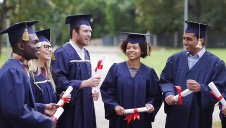 glückliche-Schüler-in-Mörtel-Boards-mit-Diplomen