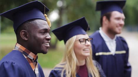 glückliche-Schüler-in-Mörtel-Boards-mit-Diplomen