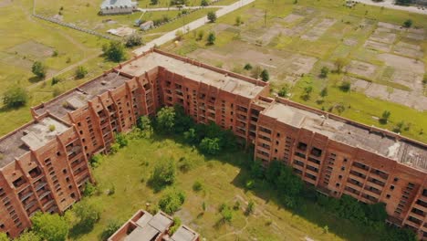 Vuelo-por-encima-de-la-vieja-construcción-abandonada.-AÉREA:-Vuelo-sobre-edificio-con-apartamentos-de-gran-altura-sin-terminar.-Vista-del-abejón.-Temporada-de-verano.-Ciudad-abandonada-después-de-desastres.-Material-de-archivo-HD