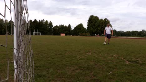 Jugador-de-fútbol-hace-juegos-malabares-una-pelota-en-la-puerta