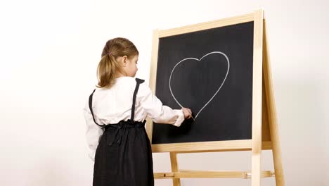 A-happy-girl-dressed-as-a-teacher-in-front-of-a-small-blackboard-holds-her-arms-folded-and-smiles.