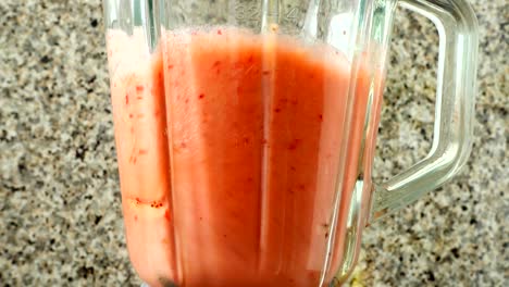 Preparation-of-cocktail-in-the-blender-from-apples,-bananas-and-strawberry.	Shooting-in-kitchen.