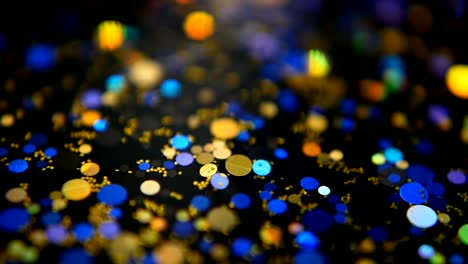 Defocused-shimmering-multicolored-glitter-confetti,-black-background.-Party,-magic,-imagination.-Rainbow-colors,-sparkle-circles.-Holiday-abstract-festive-texture-of-shiny-blurred-bokeh-light-spots.