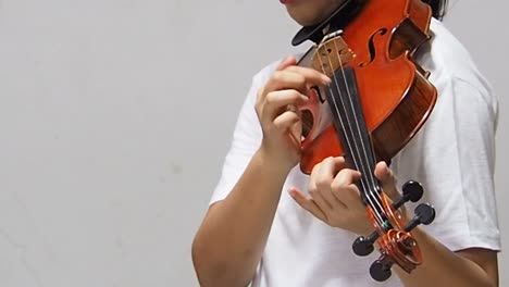 the-lady-is-showing-method-of-playing-by-plucking-the-strings-with-the-finger,the-Pizzicato-technique-of-violinist.