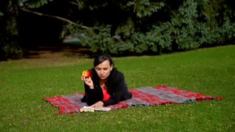 Junge-Frau-Buch-lesen-und-Apfel-Essen