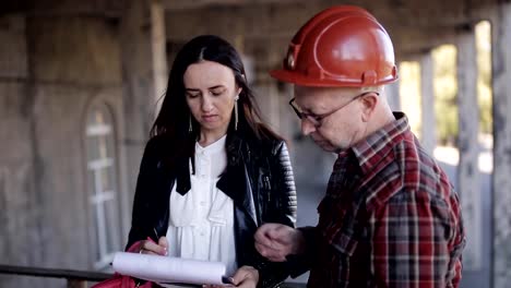 Frau-Ingenieur-und-Superintendent-im-Helm,-die-notwendigen-Materialien-und-technischen-Ressourcen-zu-diskutieren-weiterhin-Bau.