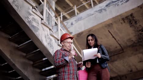 Ingeniero-de-mujer-hablando-con-un-capataz-en-la-obra,-para-resolver-los-problemas-organizacionales.