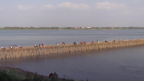 Traffic-jam-on-the-bamboo-bridge-over-the-Mekong-River;-motorbikes,-cars-,-and-people-on-foot-crossing-it-(-time-lapse)