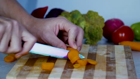 Man-is-cutting-vegetables-in-the-kitchen,-slicing-carrot