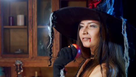 Bruja-de-Halloween-en-un-sombrero-con-una-manzana-venenosa-mira-pensativo.-Ella-sueña-con