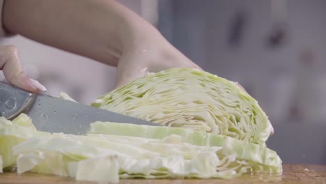 Cutting-cabbage-with-knife-on-the-wood.-Slow-motion